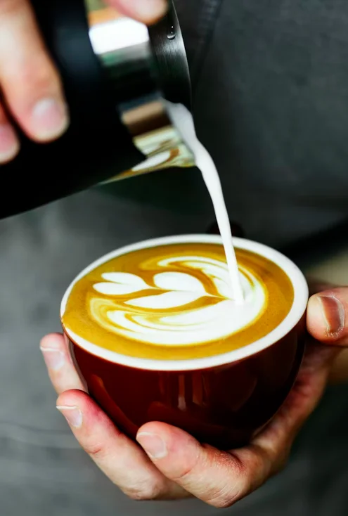 Pouring milk foam to create the perfect cappuccino layer